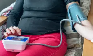 Osoba mierzy ciśnienie krwi, by sprawdzić, jakie ciśnienie krwi jest niebezpieczne.