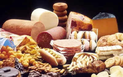 Stół ugina się od niezdrowych przysmaków: kiełbasy, sery, hamburgery, frytki, pączki i ciastka. Wiele z tych produktów zawiera tłuszcze trans.