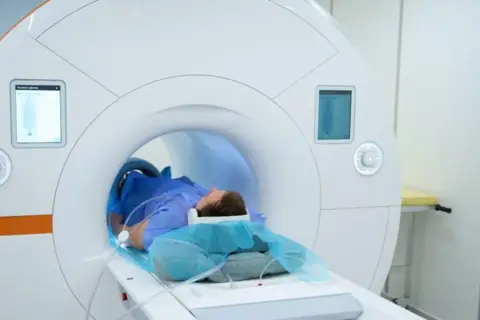 Pacjent leżący w aparacie do rezonansu magnetycznego.