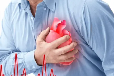 Mężczyzna trzyma dłoń na piersi, gdzie widnieje symbol serca. Obok widnieje wykres EKG, sugerujący **częstoskurcz napadowy**.