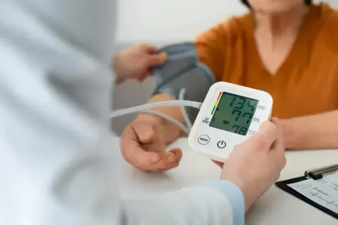 Lekarz mierzy ciśnienie pacjentowi. Zastanawiasz się nad nadciśnienie w młodym wieku przyczyny?