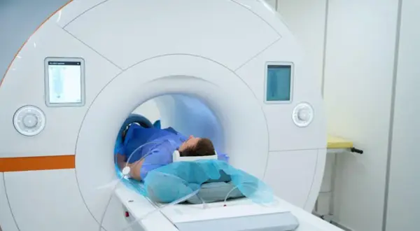 Pacjent leżący w aparacie do rezonansu magnetycznego.