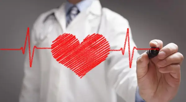 Lekarz rysuje serce i linię EKG. Może to symbolizować troskę o zdrowie serca, a nawet pomoc w radzeniu sobie ze stresem, jak Nebilet na uspokojenie.
