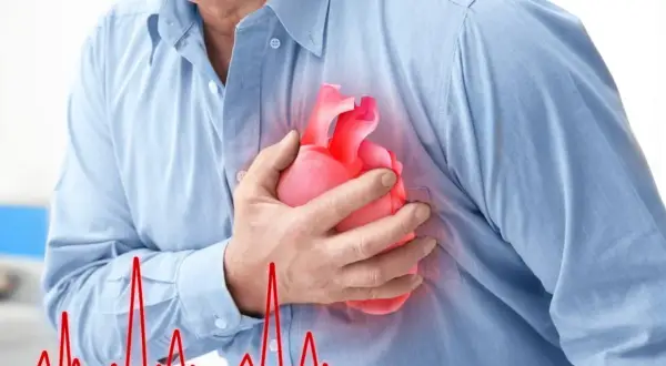 Mężczyzna trzyma dłoń na piersi, gdzie widnieje symbol serca. Obok widnieje wykres EKG, sugerujący **częstoskurcz napadowy**.