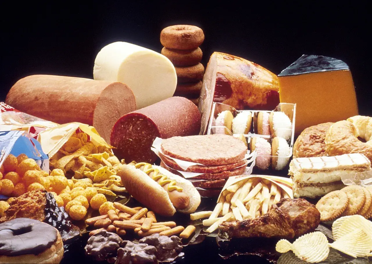 Stół ugina się od niezdrowych przysmaków: kiełbasy, sery, hamburgery, frytki, pączki i ciastka. Wiele z tych produktów zawiera tłuszcze trans.