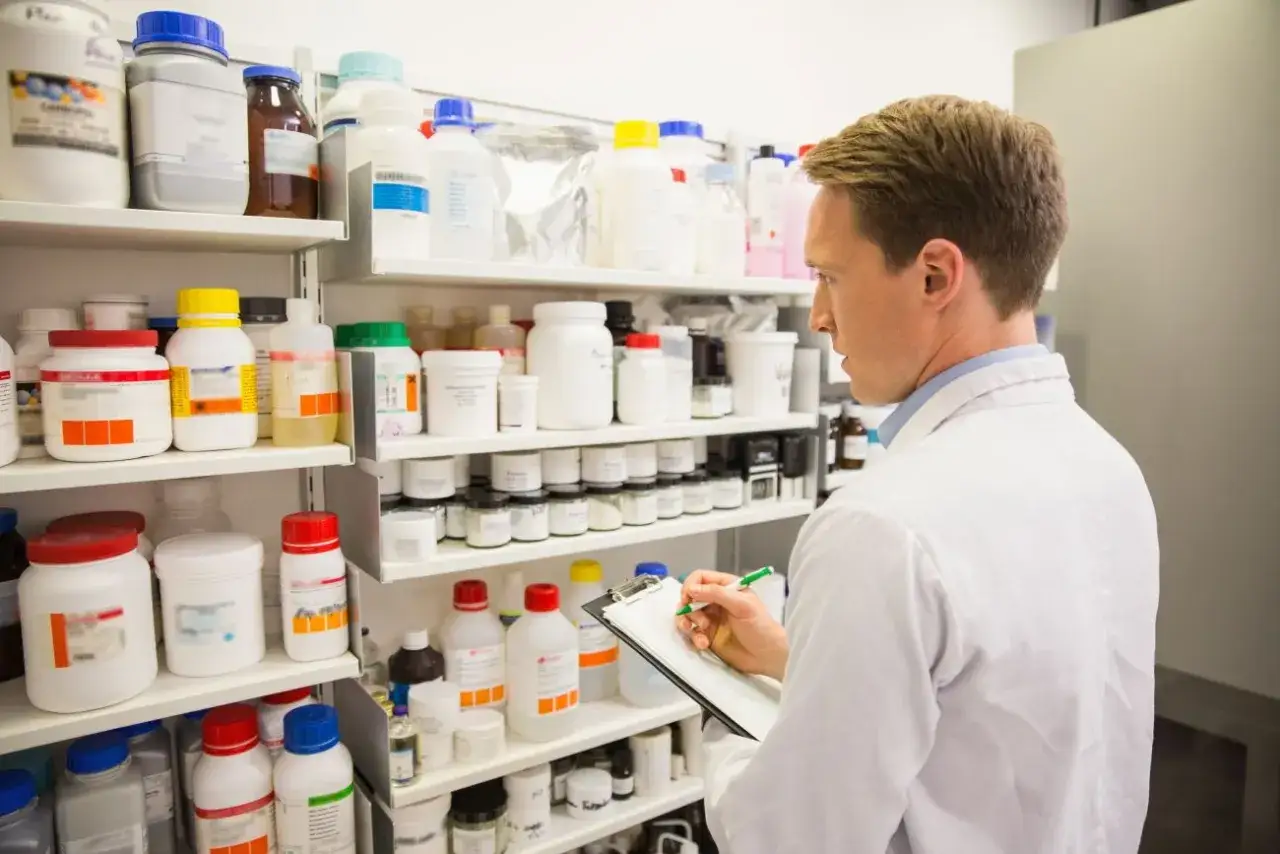 Farmaceuta notuje możliwe amlozek skutki uboczne, przeglądając półki z lekami i suplementami.